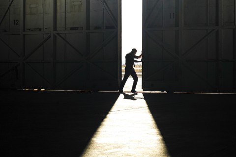 man pushing door